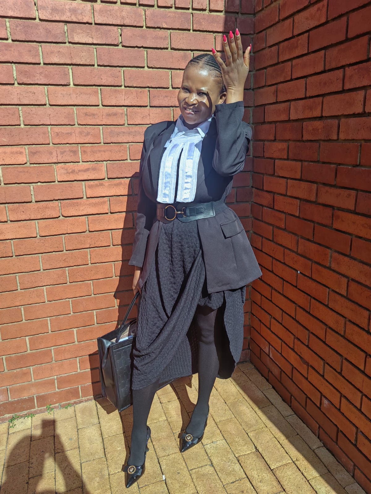 Ms Mogotlane outside the court building wearing her legal bands and black blazer